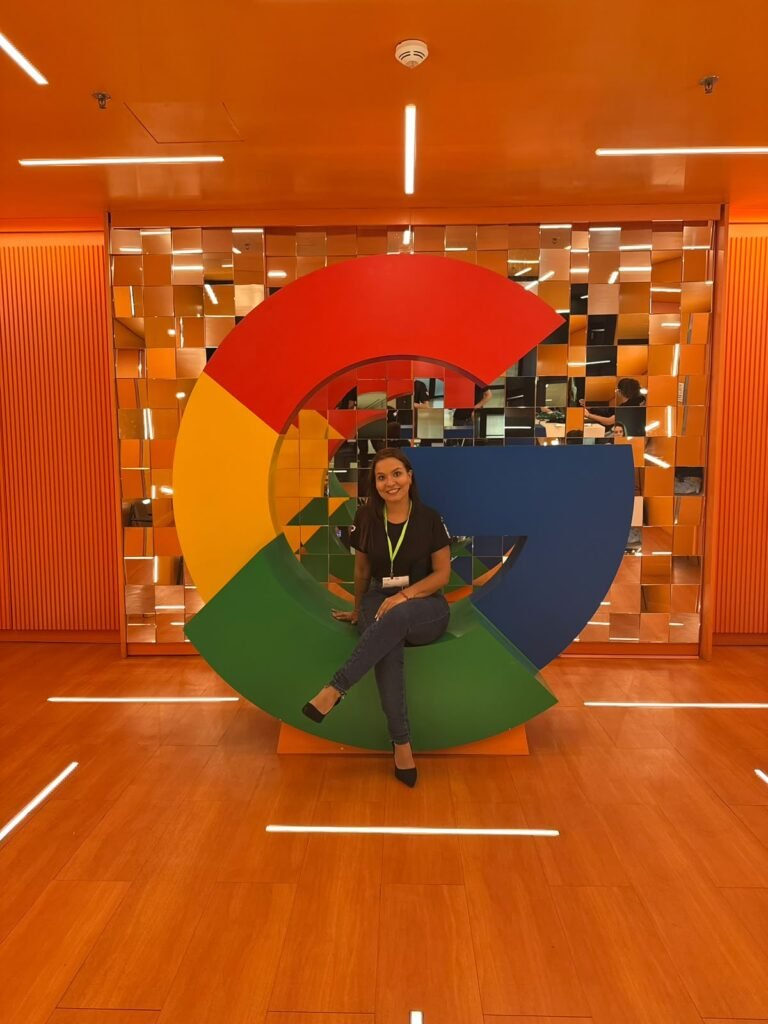 Camila Mecenas sentada no logo do Google em escritório da empresa
